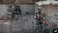 FILE - Indian paramilitary soldiers stand guard outside the main telephone exchange building in Srinagar, Indian-controlled Kashmir, Sept. 5, 2019.