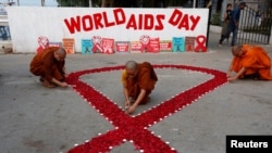 Biksu Buddha menyalakan lilin dalam peringantan Hari AIDS Sedunia di Kolkata, India, 1 Desember 2018. 