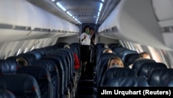 Para awak kabin di dalam kabin Delta Airlines yang nyaris kosong di tengah wabah virus corona, dalam penerbangan dari Salt Lake City, Utah, 11 April 2020.