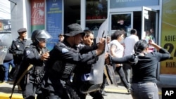 ARCHIVO - Policías antidisturbios desalojan a periodistas desde la entrada principal de su medio hasta una estación de policía en Mangua, Nicaragua, en diciembre del 2018