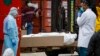 Un cuerpo envuelto en plástico va a ser colocado en u camión refrigerado usado como morgue temporaria en la ciudad de Nueva York debido a la pandemia de COVID-19 el 31 de marzo de 2020.