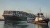 In this photo released by Suez Canal Authority, the Ever Given, a Panama-flagged cargo ship, is pulled by one of the Suez Canal tugboats, in the Suez Canal, Egypt, March 29, 2021. 