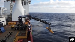 Awak kapal Ocean Shield milik Dephan Australia memindahkan kapal selam robotik milik Angkatan Laut AS, Bluefin-21 untuk misi pencarian pesawat MH370 di Samudera Hindia (14/4).