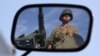 A Turkish soldier is reflected on a mirror as he stands guard on top of an armored personnel carrier on the Turkish-Syrian border near the Akcakale border crossing, October 4, 2012. 
