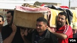 Warga menggotong peti jenazah korban pengeboman di distrik Ur, Baghdad, Irak, Jumat (28/10).