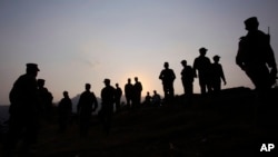 FILE - Pakistan army soldiers gather at a forward area post on the Line of Control (LOC) that divides Kashmir between Pakistan and India, in Tatta Pani, 200 kilometers from Islamabad, Pakistan, Oct. 1, 2016. 