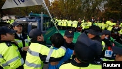 Petugas polisi Korea Selatan menghentikan warga Paju mendekati kendaraan aktivis anti Korea Utara dekat zona demilitarisasi yang memisahkan dua Korea di Paju, 25 Oktober 2014. 