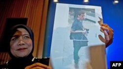 Polisi Malaysia menunjukkan foto pemuda Iran berusia 19 tahun, Pouria Nour Mohammad Mehrdad, salah satu dari dua pria penumpang Malaysia Airlines penerbangan MH370 yang menggunakan paspor curian. (AFP/Manan Vatsyayana)