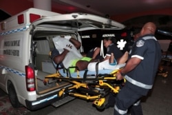 An injured inmate is carried on a stretcher into a hospital by police paramedics after a shootout among inmates at La Joyita prison, in Panama City, Panama, Dec. 17, 2019.