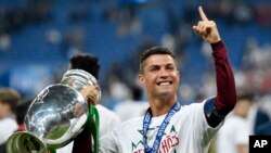 Cristiano Ronaldo brandit le trophée après avoir remporté l'Euro 2016 à l’issue du match entre le Portugal et la France au Stade de France à Saint-Denis, au nord de Paris, le dimanche 10 juillet 2016. (AP Photo / Martin Meissner)