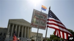 Para pendukung peraturan imigrasi Arizona 'perlihatkan dokumen-dokumenmu' memberikan dukungan di depan Mahkamah Agung di Washington DC saat berlangsungnya dengar pendapat di gedung itu (25/4)