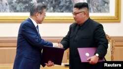 문재인 한국 대통령과 김정은 북한 국무위원장이 지난 19일 평양 백화원 영빈관에서 평양공동선언문에 서명한 후 악수하고 있다. 평양사진공동취재단. 