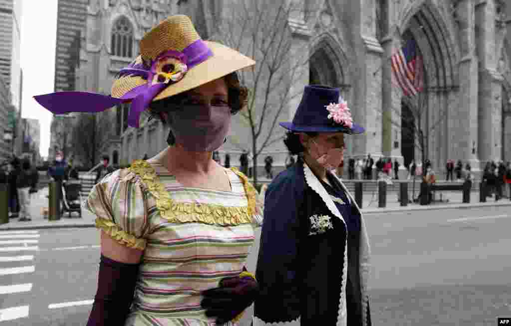 Dos mujeres caminan fuera de la Catedral de San Patricio en Nueva York el 4 de abril de 2021, después de los servicios de Pascua al 50% de su capacidad. El desfile anual de Pascua y el Festival Bonnet en la Quinta Avenida se volvieron virtuales.