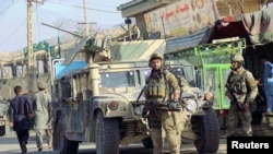Pasukan keamanan Afghanistan berjaga di depan kendaraan lapis baja mereka di Kunduz, Afghanistan (4/10). 