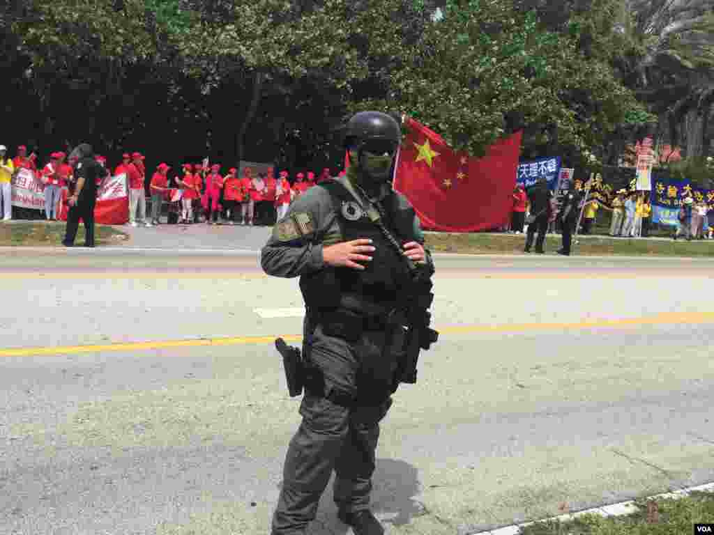 防爆警察与聚集在习近平下塌酒店附近的人群(美国之音莉雅拍摄)。这张图片中有穿红色上衣的欢迎习近平的人群,有人称他们为红衫军,也有法轮功示威者。