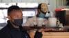 FILE - Deaf waiter Michael Mwangi walks to serve customers amid the COVID-19 pandemic, at the Pallet Cafe in Lavington area of Nairobi, Kenya, August 23, 2021.