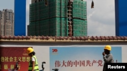 资料照：中国工人从云南省昆明市一处碧桂园开发的建筑工地旁走过。（2019年9月17日）
