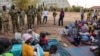 Des responsables des Forces de défense du peuple du Sud-Soudan rendent visite à des habitants réfugiés au quartier général de l'armée après une nuit de violence à Juba, au Sud-Soudan, le 17 janvier 2025.