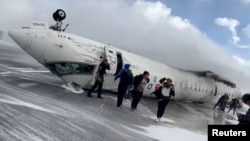 Los pasajeros abandonan un avión CRJ-900 de Delta Air Lines después de que se estrellara al aterrizar en el Aeropuerto Internacional Pearson de Toronto en Mississauga, Ontario, Canadá, el 17 de febrero de 2025, en una imagen fija de un video