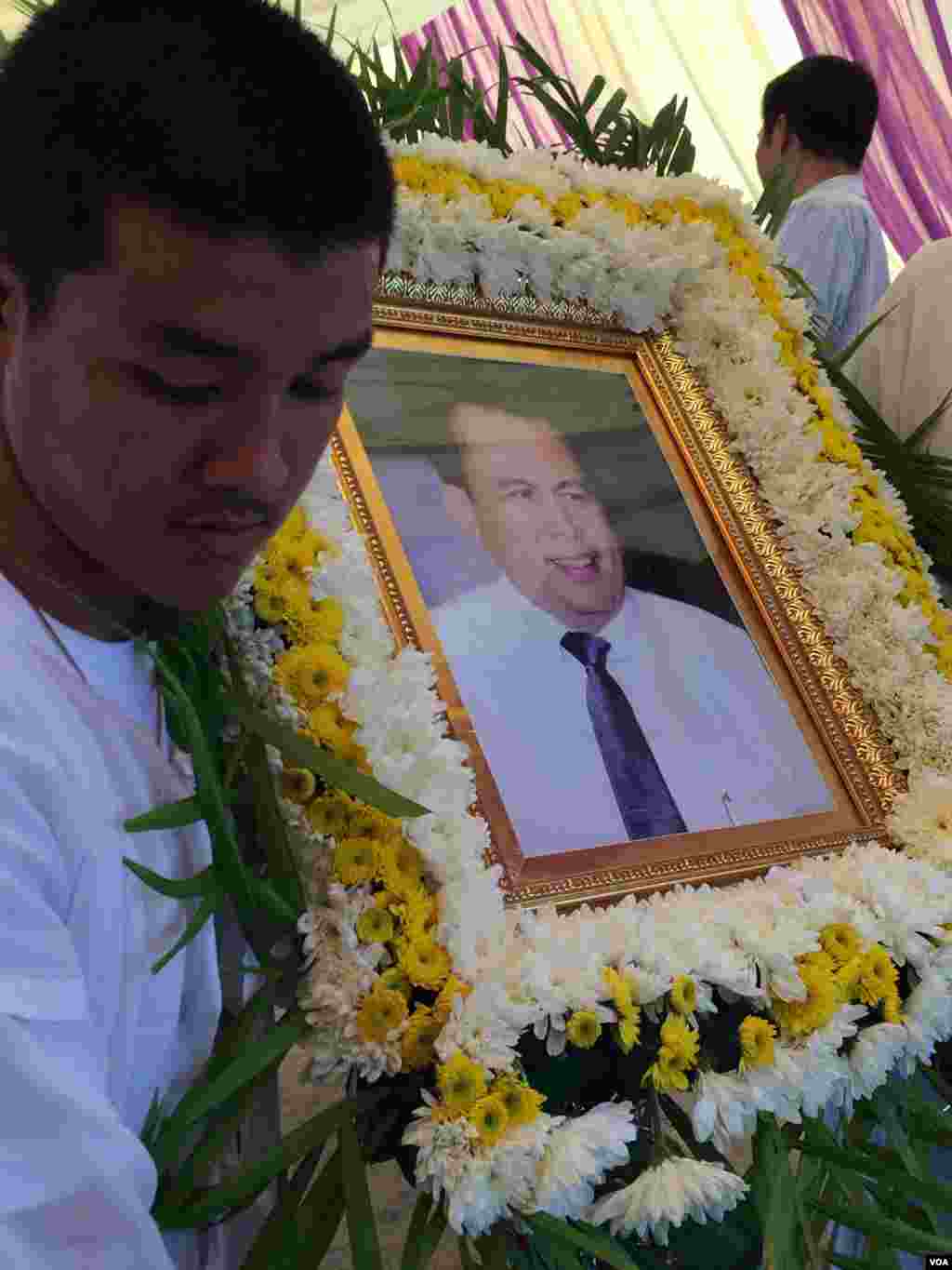 រូបថត​របស់​លោក ​កែម ឡី ត្រូវបានគេ​លើក​យក​ទៅ​ដាក់​នៅ​មុខ​ផ្នូរ មុនពេល​បញ្ចុះ​សព​នៅព្រឹក​ថ្ងៃច័ន្ទ ទី២៥ ខែកក្កដា ឆ្នាំ២០១៦។​ (ផន បុប្ផា/VOA)
