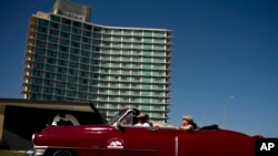 ARCHIVO - Un automóvil estadounidense antiguo traslada a unos turistas frente al hotel Riviera, en La Habana, Cuba, el 24 de abril de 2019. (AP Foto/Ramón Espinosa)