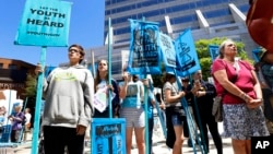 Supporters attend a rally Tuesday, June 4, 2019 for a group of young people who filed a lawsuit saying U.S. energy policies are causing climate change and hurting their future.