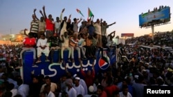 Para demonstran meneriakkan slogan saat menggelar protes anti-pemerintah di luar kantor Menteri Pertahanan Sudan di Khartoum, 21 April 2019.