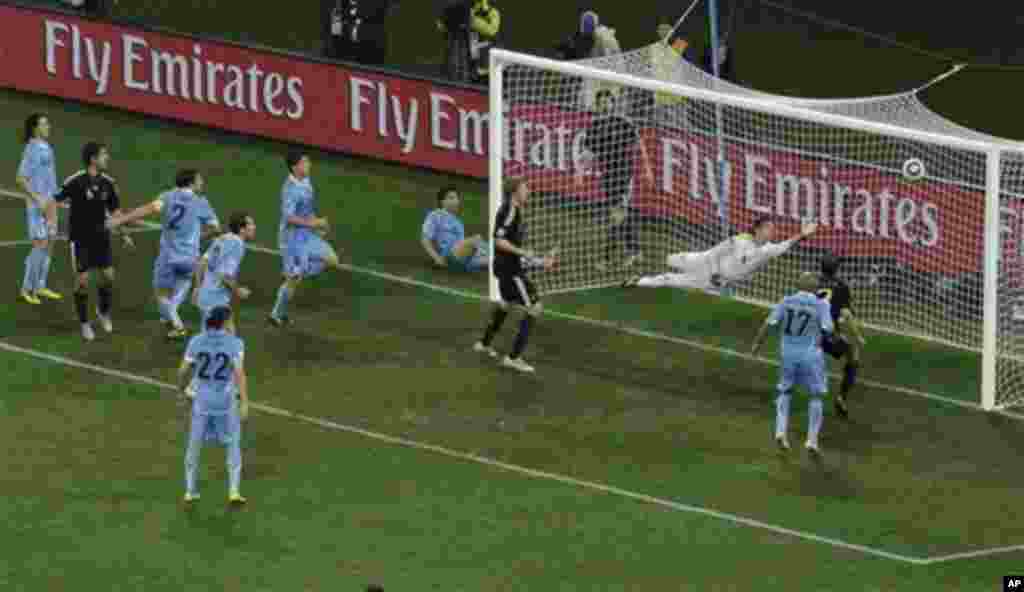 Germany's Sami Khedira, second from left, scores his side's third goal past Uruguay goalkeeper Fernando Muslera, third right, during the World Cup third-place soccer match between Germany and Uruguay at Nelson Mandela Bay Stadium in Port Elizabeth, South