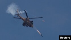 Un helicóptero Apache de las fuerzas militares israelíes dispara misiles hacia Gaza, en medio del conflicto en curso entre Israel y el grupo islamista palestino Hamás, visto desde el sur de Israel, el 14 de mayo de 2024. REUTERS/Amir Cohen