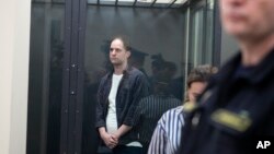 ARCHIVO - Evan Gershkovich, reportero del Wall Street Journal, izquierda, en una jaula de vidrio en una sala del Tribunal Primero de Apelaciones de Jurisdicción General en Moscú, Rusia, el martes 23 de abril de 2024. 