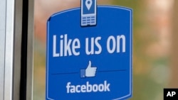 FILE - A sign with Facebook's "Like" logo is posted at Facebook headquarters in Menlo Park, California. 