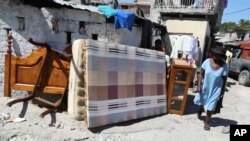 ARCHIVO: Haitianos huyen de sus casas con lo que pueden llevar para escapar de la violencia de las pandillas en el vecindario de Solino, en Puerto Príncipe, el 26 de octubre de 2024.