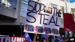 Partidarios del presidente Donald Trump se reúnen con carteles donde se lee: "Pare el robo", el alusión a supuesto fraude en conteo de votos, en el Centro de Convenciones de Filadelfia, el viernes 6 de noviembre de 2020..