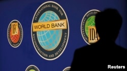 FILE - A man is silhouetted against the logo of the World Bank at the main venue for the International Monetary Fund (IMF) and World Bank annual meeting in Tokyo October 10, 2012. The World Bank said on Monday it expects its nonmarket rate lending to top $43 billion in the current fiscal year as developing countries face economic headwinds.