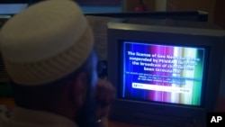 FILE - A Pakistani viewer looks at a television screen flashing suspension notice of GEO News channel in Islamabad, Pakistan, June 6, 2014. 