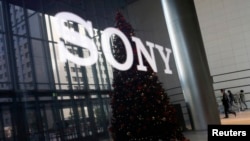 FILE - The logo of Sony Corp and a Christmas tree are reflected on the company's 4K television set at the company's headquarters in Tokyo. 