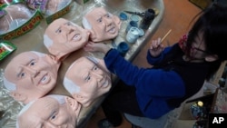 An employee adds details to rubber masks depicting President-elect Joe Biden at the Ogawa Studios in Saitama, north of Tokyo, Nov. 11, 2020.