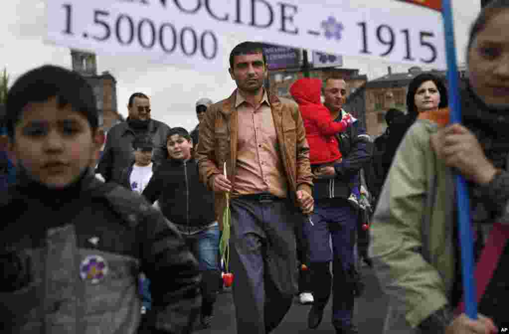Armenians carry a placard with a sign reading "1915" and "1,500,000," the year and numbers of victims of mass killings of Armenians by Ottoman Turks on a city street in Yerevan, Armenia, April 24, 2015.