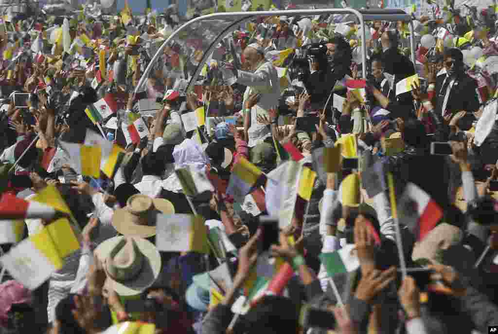 Catholic faithful cheer as Pope Francis drives by in his popemobile in Ecatepec, Mexico, Feb. 14, 2016.