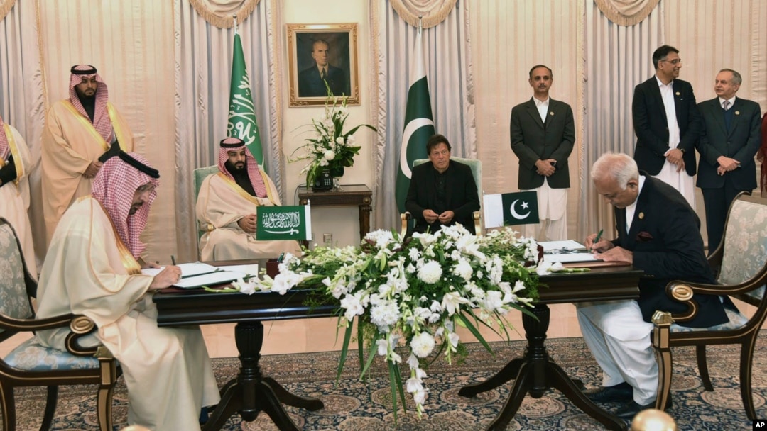 Visiting Saudi Arabia's Crown Prince Mohammed bin Salman, center left, and Pakistani Prime Minister Imran Khan, center right, witness the signing ceremony of the Memorandum of Understanding (MOU) on Petroleum, in Islamabad, Pakistan, Sunday, Feb. 17, 2019.