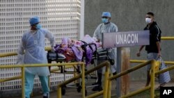 Trabajadores de la salud reciben a otro paciente sospechoso de tener el COVID-19 en el Hospital Universitario de Brasilia el 5 de agosto.