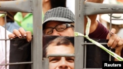 Un seguidor del expresidente Rafael Correa sostiene una imagen del mandatario mientras aguardan a que abandone el país rumbo a Bélgica, el 10 de julio de 2017.
