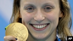 Katie Ledecky menunjukkan medali emasnya untuk nomor gaya bebas 800 meter putri di Rio de Janeiro, Brazil (12/8). 