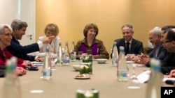 U.S. Secretary of State John Kerry, second left, meets with EU High Representative for Foreign Affairs, Catherine Ashton, center, and Iranian Foreign Minister Mohammad Javad Zarif, third right, at the Iran Nuclear talks in Geneva, Nov. 9, 2013.