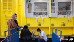 An healthcare worker measures the blood pressure of a woman who came to be tested for the coronavirus at a mobile testing station, in east Jerusalem, July 21, 2020.