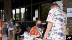One-stop operator Vickie Gregorio with the Heartland Workforce Solutions talks to a jobseeker outside the workforce office in Omaha, Nebraska, July 15, 2020.