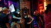 Lindsey Pettita (ketiga dari kiri), manajer bar "The Jackalope" berbincang dengan petugas pengawas minuman alkohol Texas untuk memeriksa aturan jarak aman untuk meredam penyebaran virus corona (Covid-19), setelah bar buka kembali, di Austin, Texas, 22 Mei 2020. (Foto: dok)