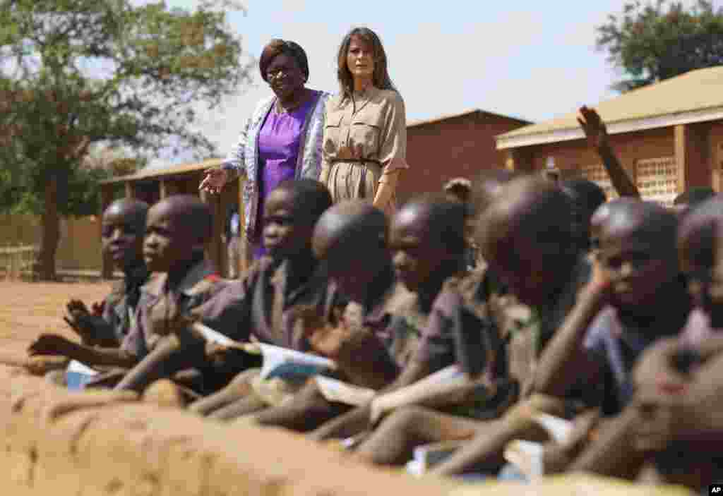 First lady Melania Trump walks with head teacher Maureen Masi to observe an outdoor class as she visits Chipala Primary School, in Lilongwe, Malawi, Oct. 4, 2018.