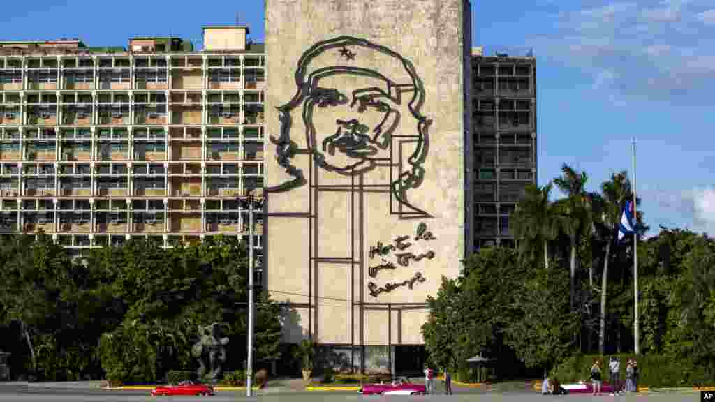 Les touristes marchent devant l'image de Ernesto "Che" Guevara, à la Place de la révolution près à Cuba, le 27 Novembre 2016.