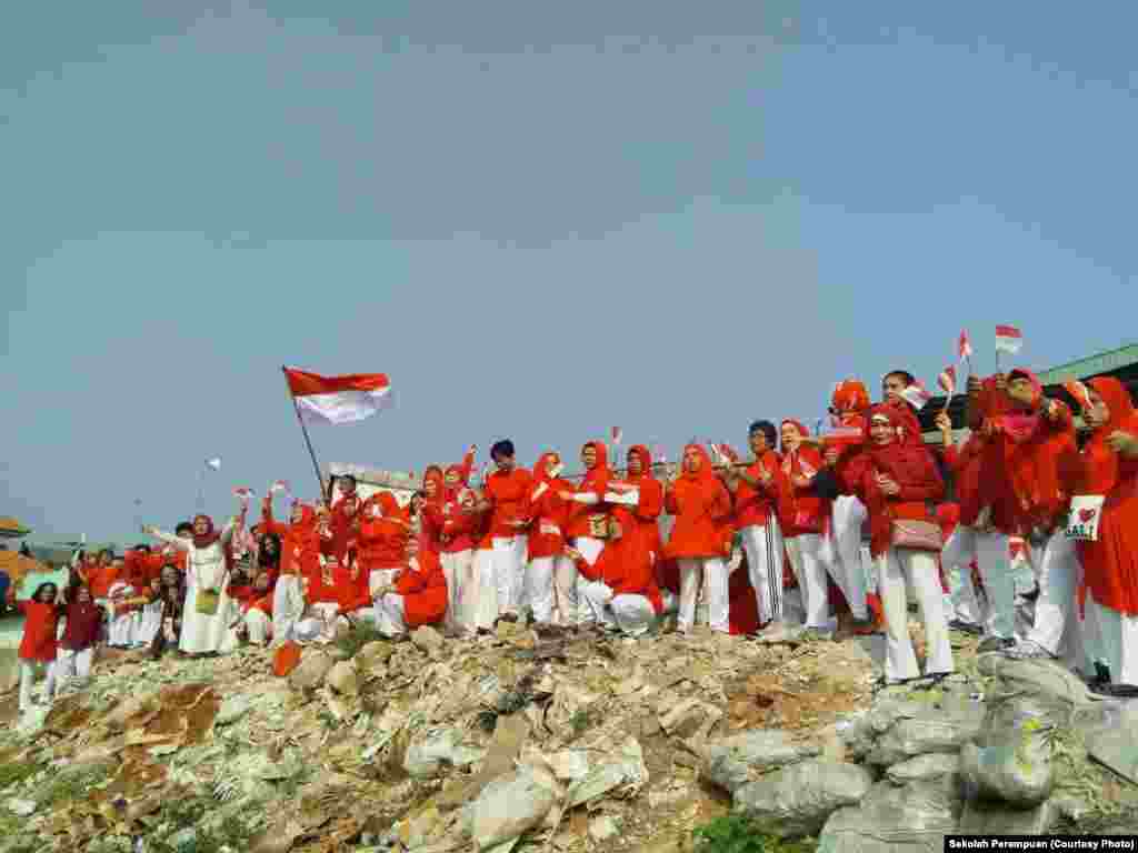 Puluhan peserta didik “Sekolah Perempuan” di bantaran Kali Ciliwung, Jakarta, memperingati Ulang Tahun ke-73 Republik Indonesia dengan cara sederhana, mengenakan pakaian merah-putih dan berbaris bersama. (Foto: Sekolah Perempuan)